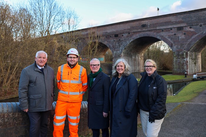 Line up of people including Mayor and Transport Secretary in front of the restored Parkhead Viaduct