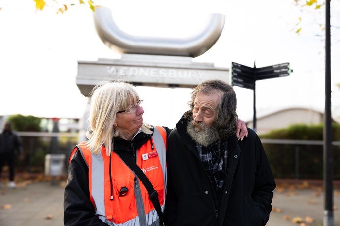 Sue Tycer in hi-vis uniform arm on shoulder with Jeff outside Wednesbury Bus Station