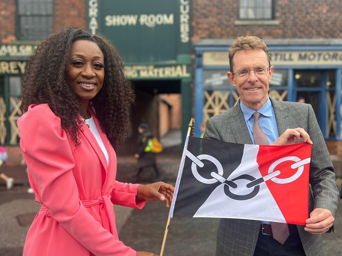 Andy Street and Beverley Knight smiling at the camera holding a Black Country flag at the Black Country Museum