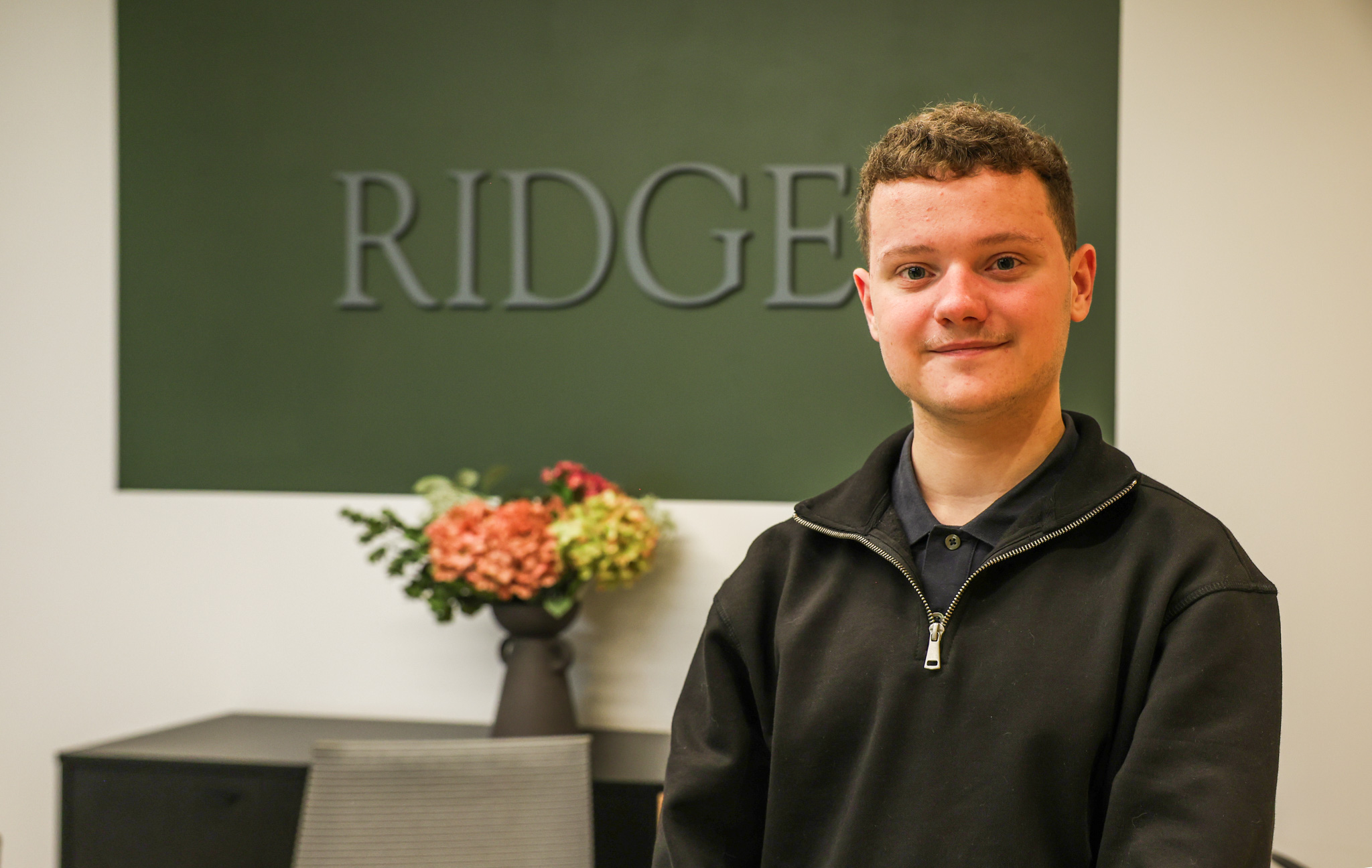 Ethan Banks standing in front of sign at Ridge and Partners LLP