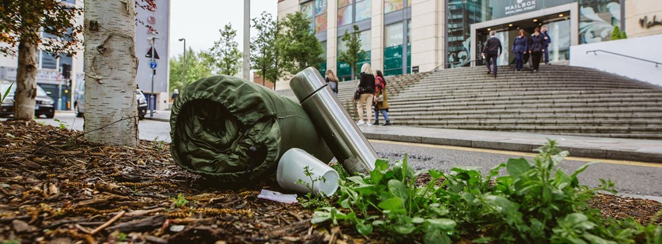 Image of a flask and sleeping bag outside an office building