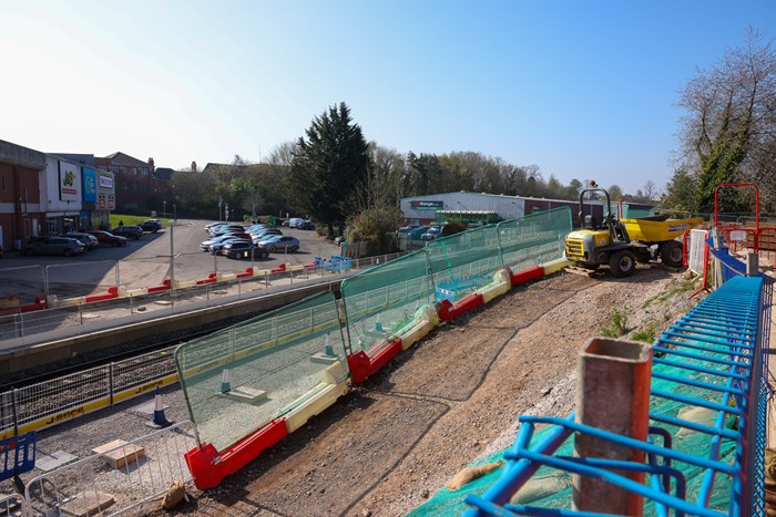 Kings Heath Station site with platforms taking shape alongside the rail track. A yellow digger is in the photo