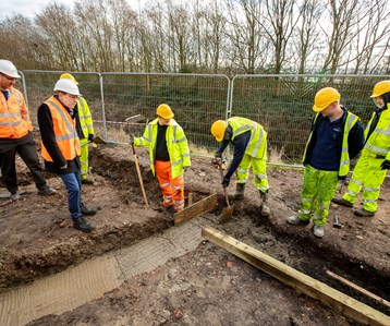 7 construction workers digging into the ground
