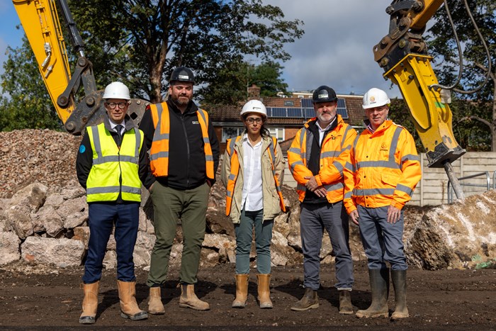 Five people dressed in protective gear lined up at the Warwick Road development site.