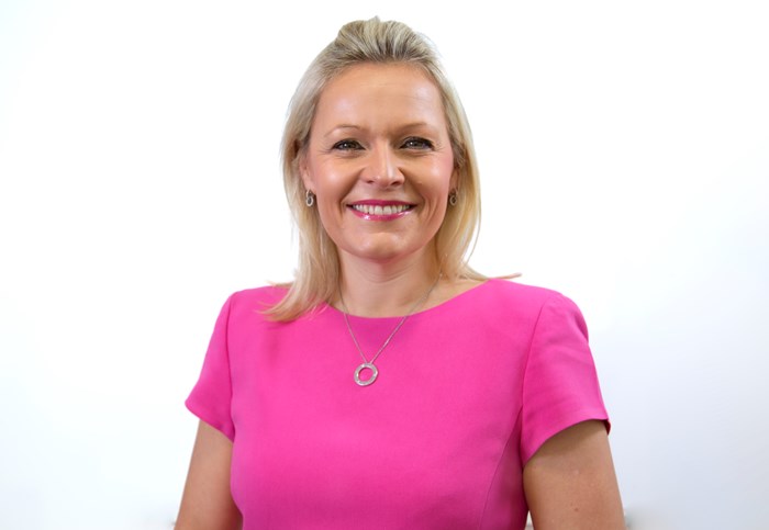 A headshot of a women looking directly at the camera