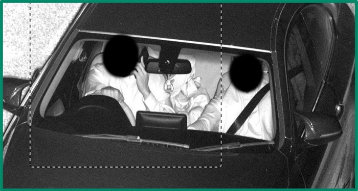 Camera image shows driver with no seatbelt and phone held to their ear