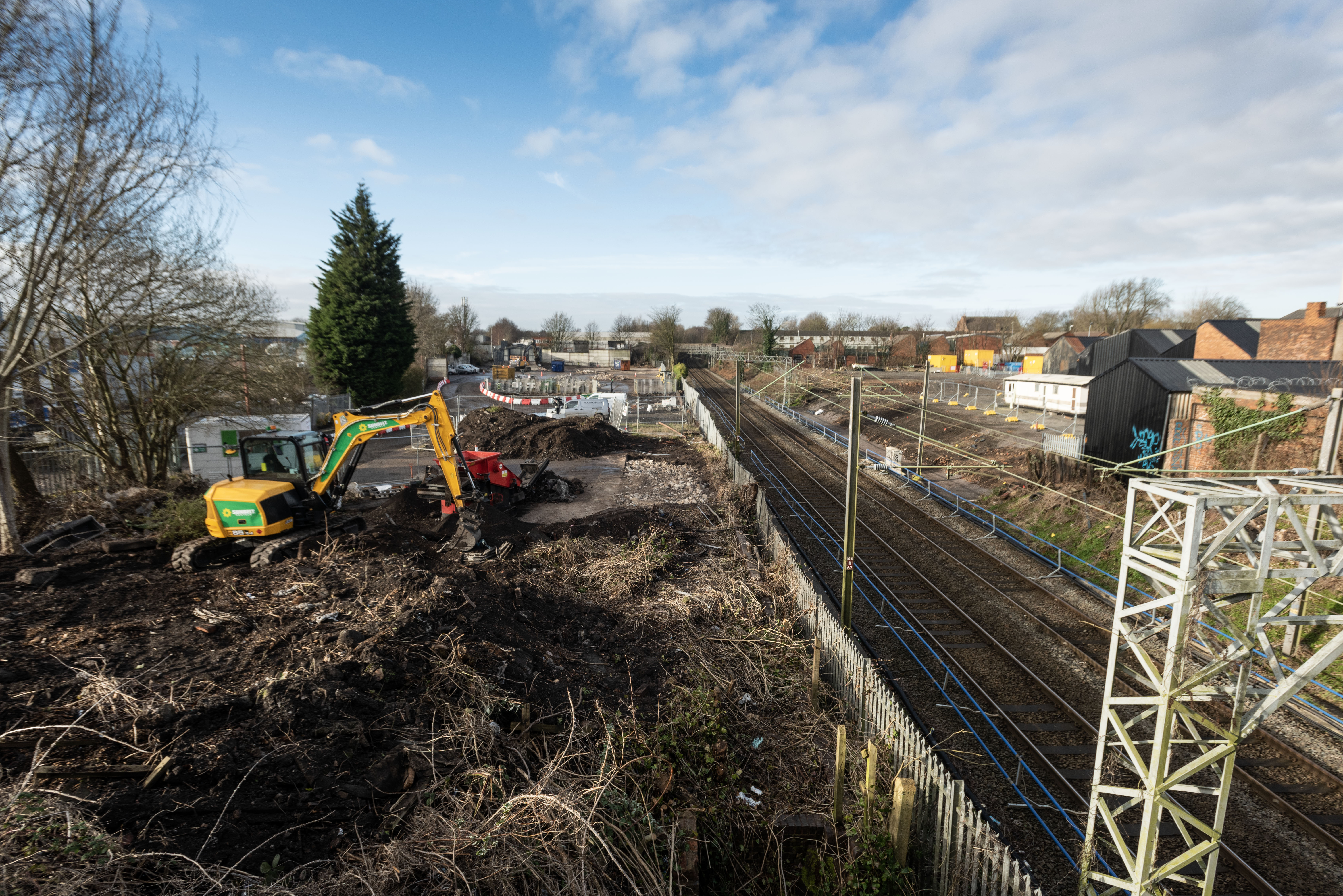 Willenhall Station demolition and building site with giant digger and railway track alongside