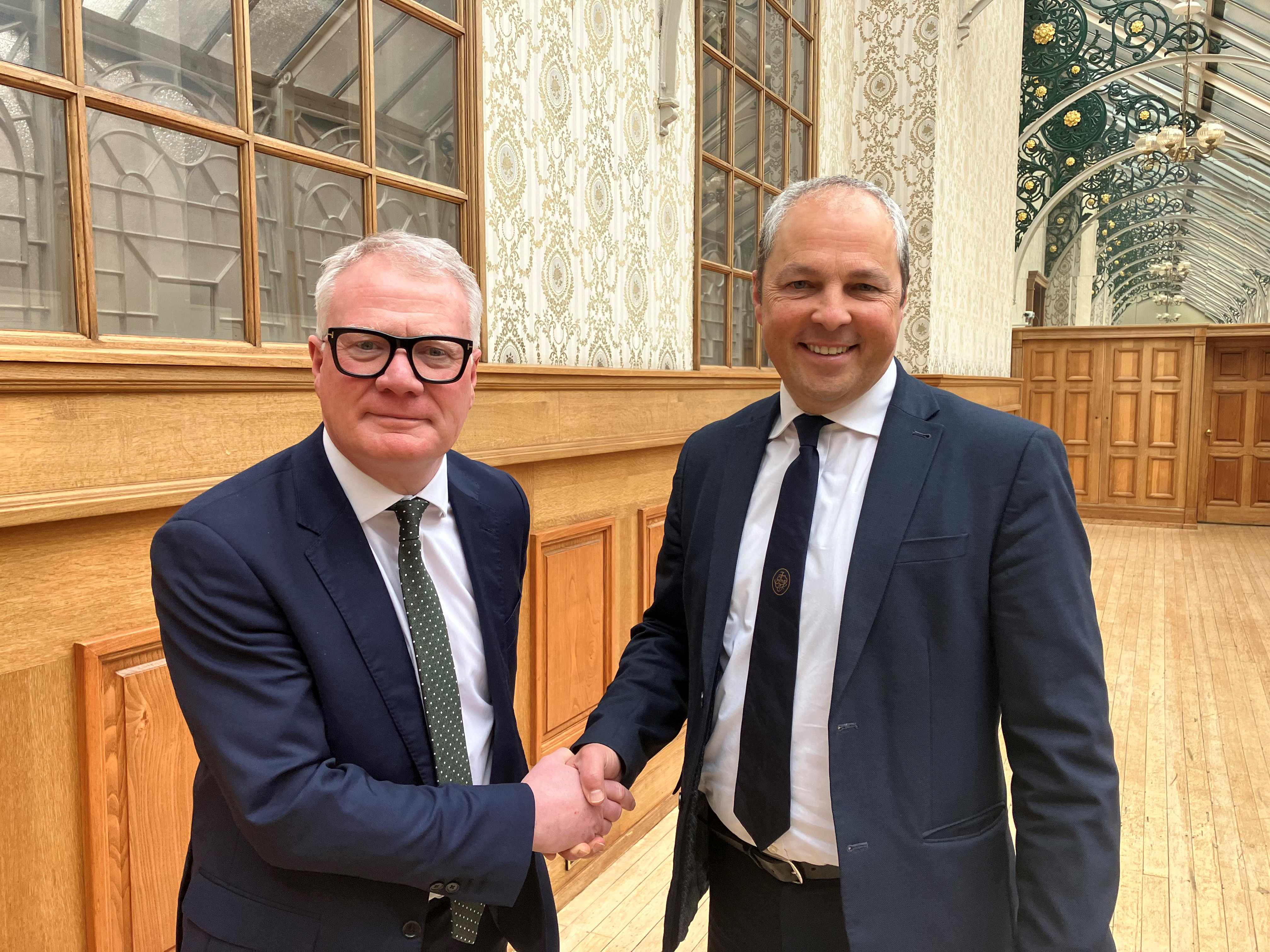 Richard Parker, Mayor of the West Midlands, with Ed Cox, who has become the West Midlands Combined Authority chief executive. The men are pictured shaking hands, wearing suits as they face the camera. They are pictured in a wooden panel room