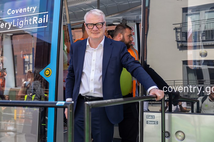 The Mayor is standing in the doorway of a Very Light Rail vehicle