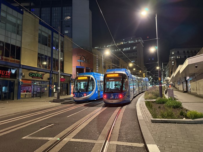 Two trams at night on a shopping street in Birmingham