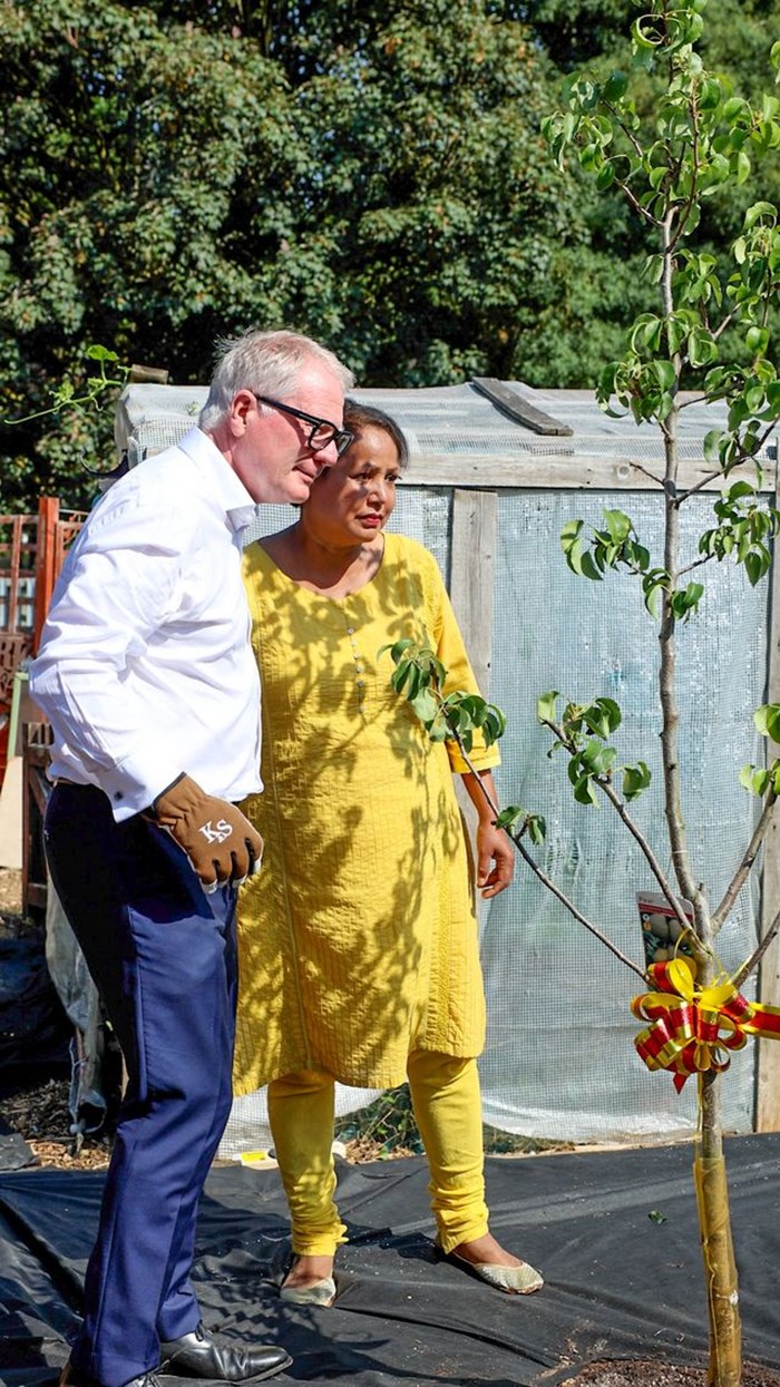 Richard Parker, Mayor of the West Midlands and Jaswinder Kaur with the pear tree they planted at the new community allotment in Tipton