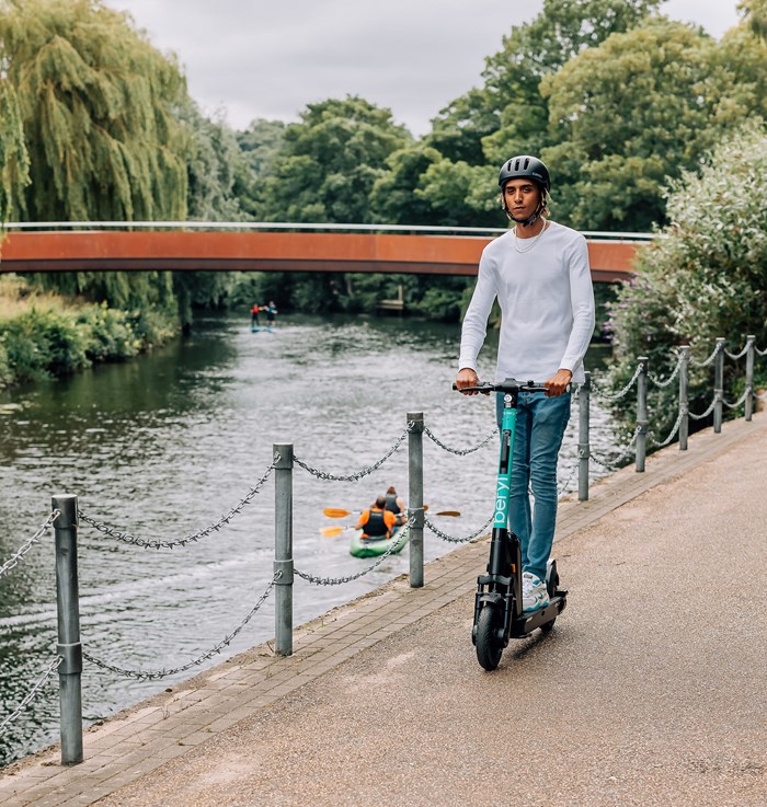 A Beryl e-scooter being ridden alongside a river