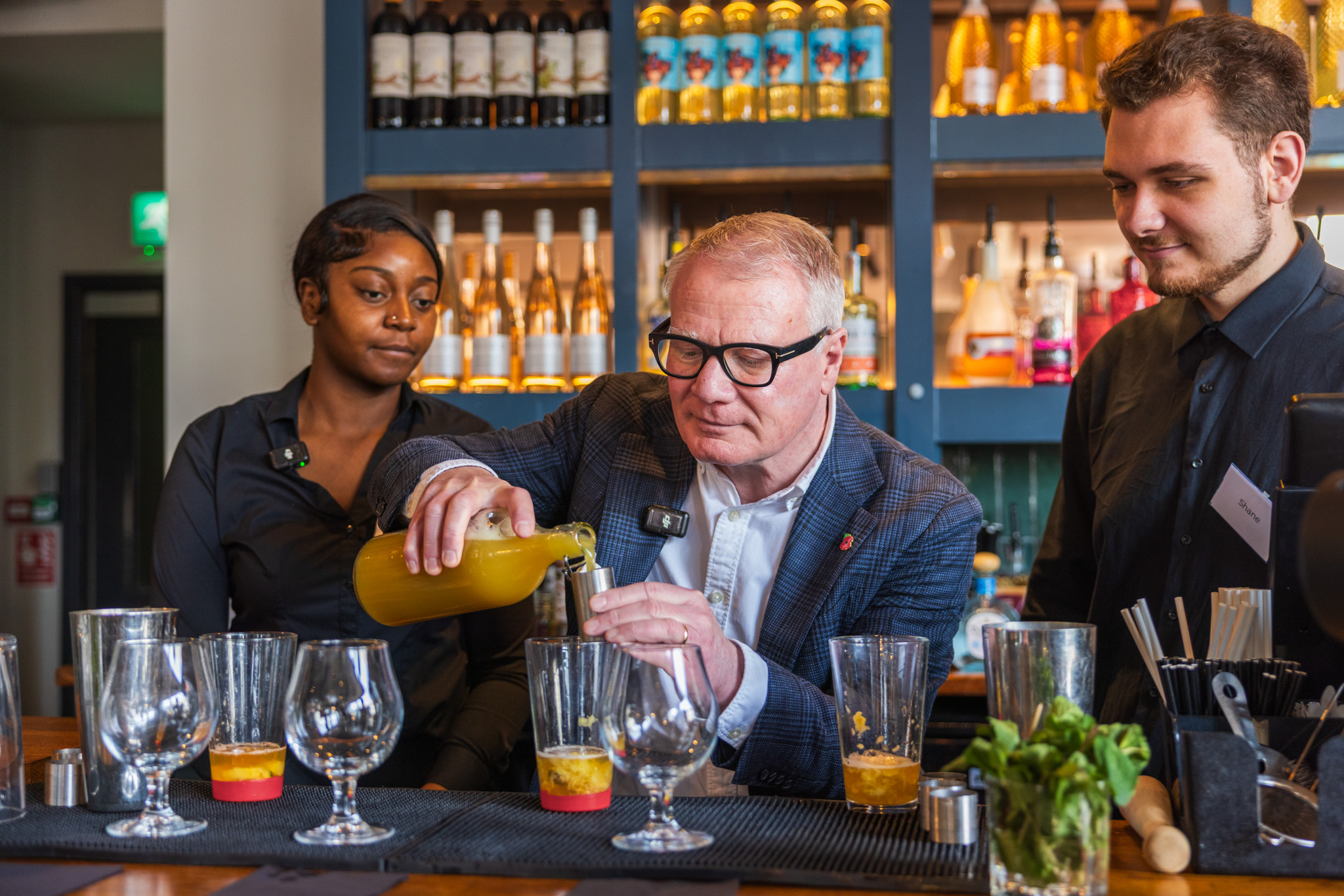 Students Tamara Pinnock (left) and Shane Masters (right), showing the Mayor Richard Parker (centre), the art of cocktail making at All Bar One.