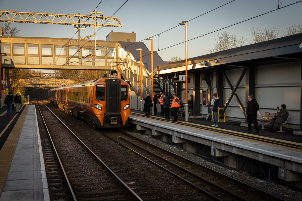 Train pulls into station where people are waiting