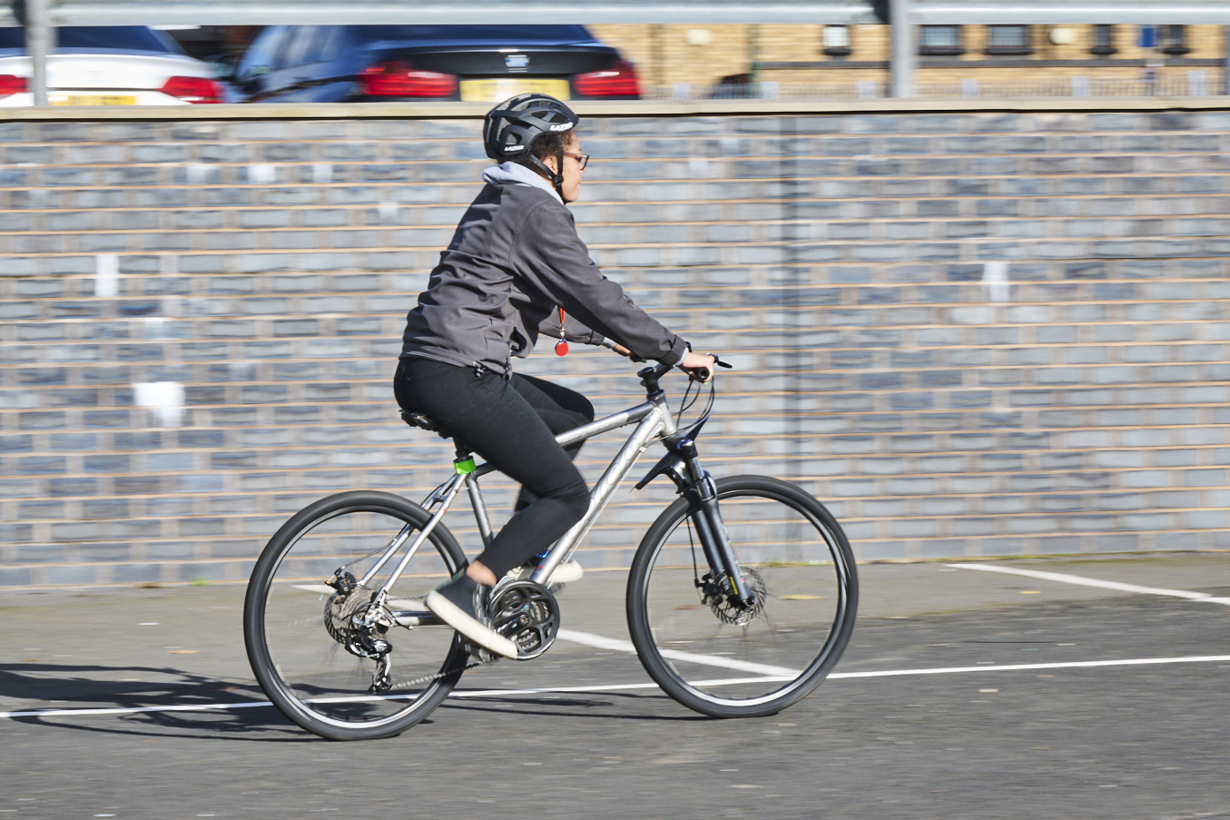A woman rides on a bike wearing a helmet