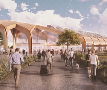 “Computer-generated image of the planned Interchange Station showing a modern building with a glass façade, landscaped public space, trees, and people walking outside.”