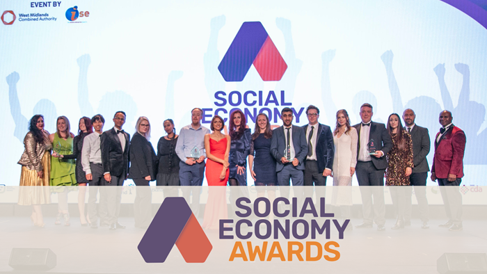 Winners of the 2024 Social Economy Awards stand side-by-side on stage.