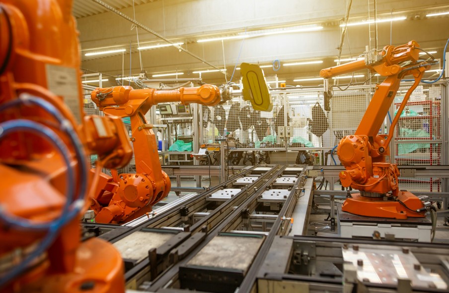 A factory with various machines and orange robotic arms