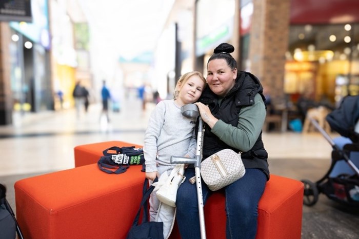 Hayley Bagnell with her daughter Miah, aged seven on a ‘number sofa’ at Touchwood Shopping Centre, Solihull, after signing up to find out how Multiply can help her.